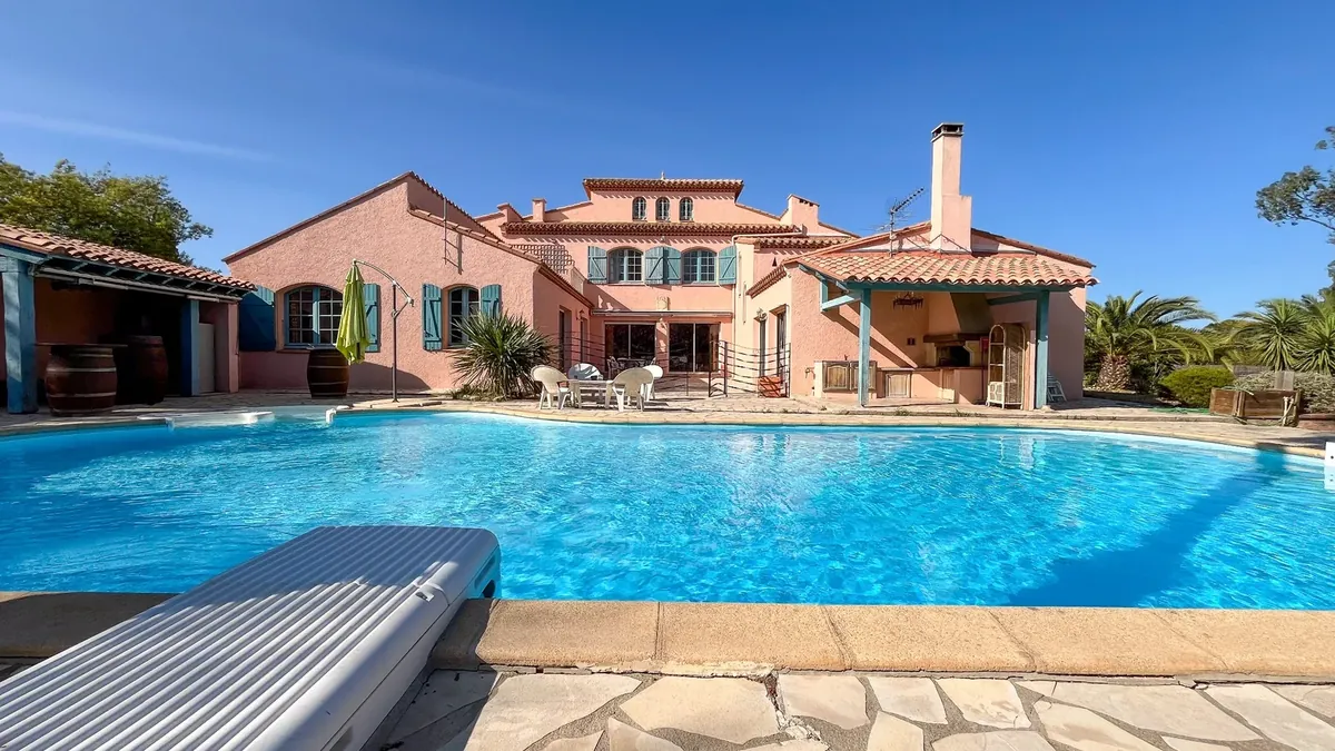 Maison aux façades terracotta avec piscine et terrasse en pierre